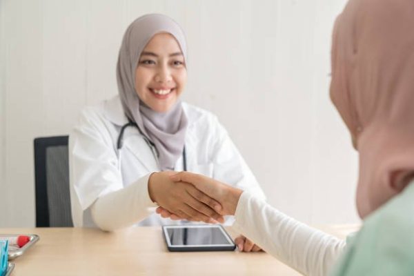 Selective focus on handshake. Muslim doctor and females patient shaking hands in the hospital. Relationship of physician well-being to interaction with people. Healthcare, Insurance, Medical concepts